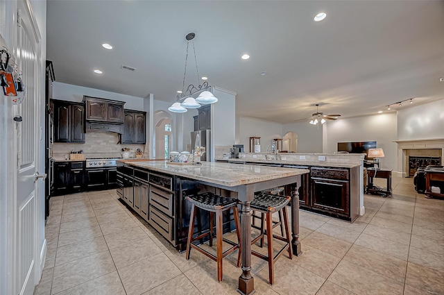 kitchen featuring a center island, a breakfast bar, stainless steel appliances, open floor plan, and a peninsula