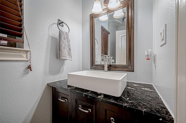 bathroom featuring a textured wall and vanity