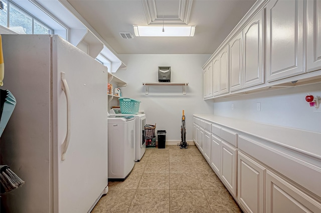 laundry room featuring cabinet space, light tile patterned floors, baseboards, visible vents, and separate washer and dryer