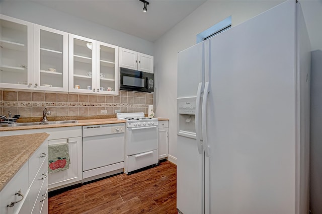 kitchen featuring white appliances, a sink, white cabinetry, light countertops, and glass insert cabinets