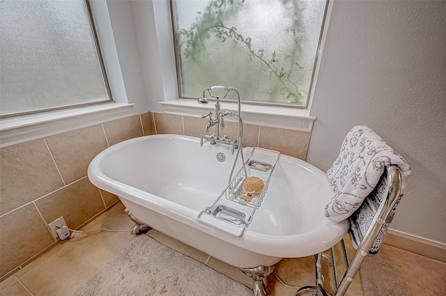 bathroom with a freestanding bath and tile patterned floors