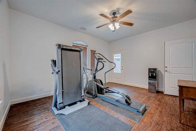 workout room with baseboards, visible vents, dark wood finished floors, and a ceiling fan