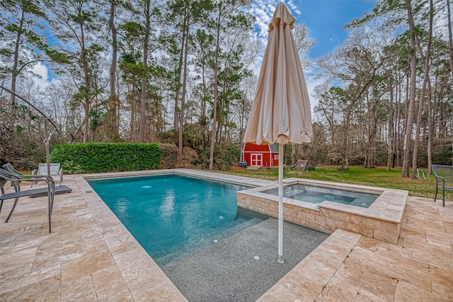 outdoor pool with a patio and an in ground hot tub