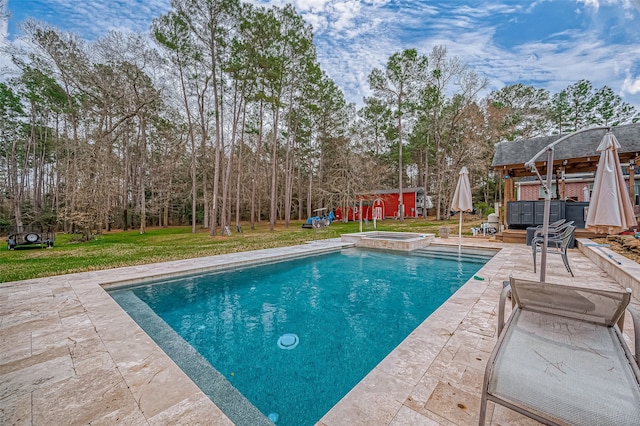 view of pool with an outbuilding, a patio, a lawn, and a pool with connected hot tub