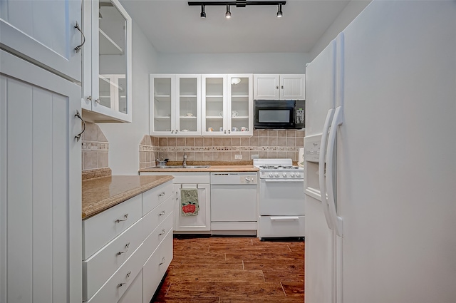 kitchen featuring white appliances, wood finished floors, white cabinetry, decorative backsplash, and glass insert cabinets