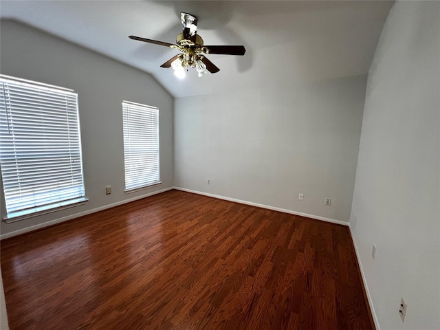 empty room with vaulted ceiling, dark hardwood / wood-style floors, and ceiling fan