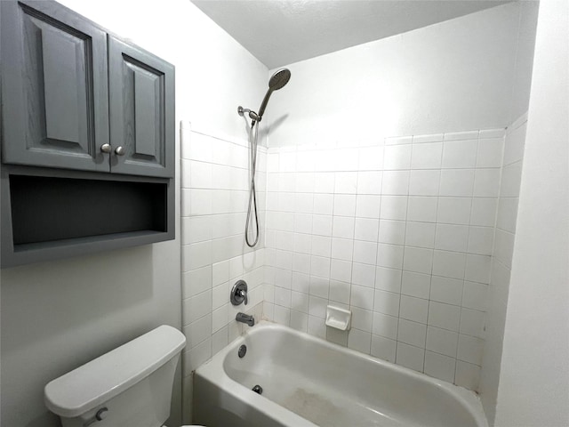 bathroom with tiled shower / bath combo and toilet