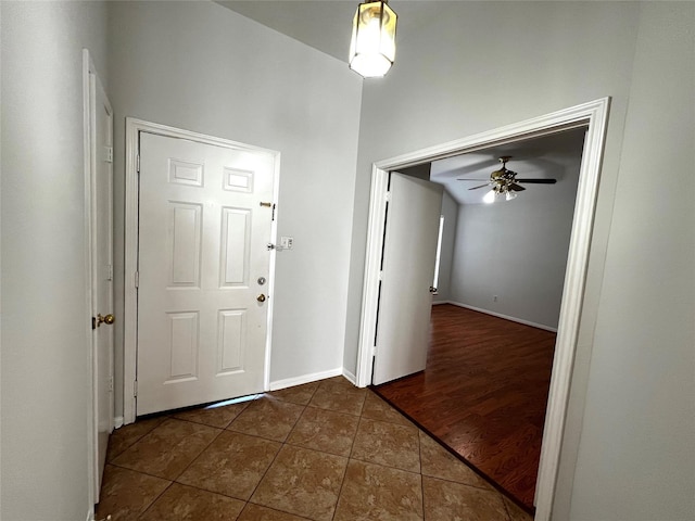 foyer featuring dark tile patterned flooring and ceiling fan