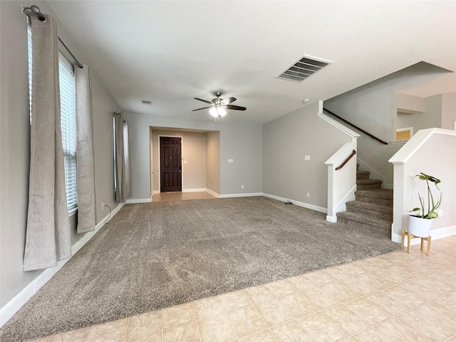 unfurnished living room featuring light carpet and ceiling fan