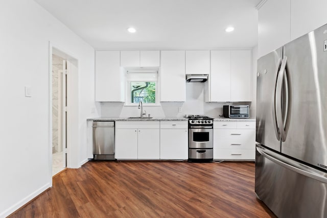 kitchen featuring sink, appliances with stainless steel finishes, dark hardwood / wood-style floors, light stone countertops, and white cabinets