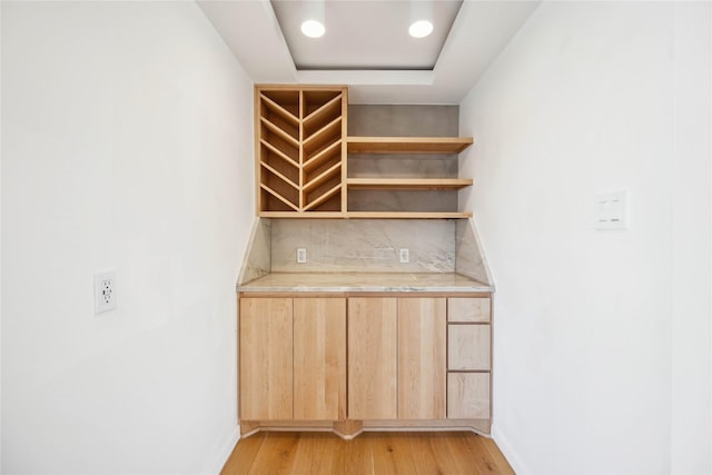 interior space with light hardwood / wood-style floors and a tray ceiling