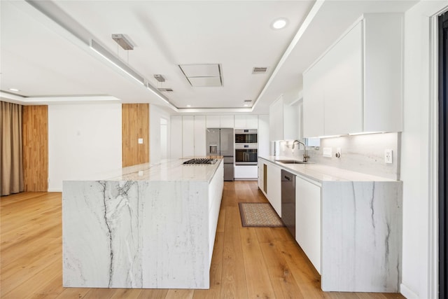 kitchen featuring white cabinetry, sink, stainless steel appliances, and a center island