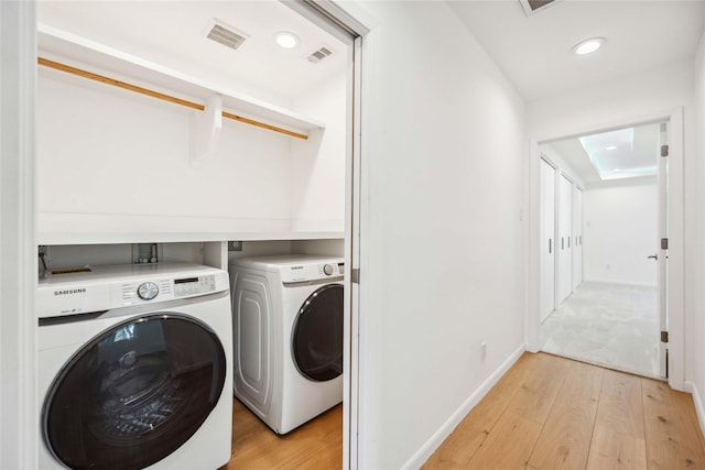 washroom featuring separate washer and dryer and light hardwood / wood-style floors