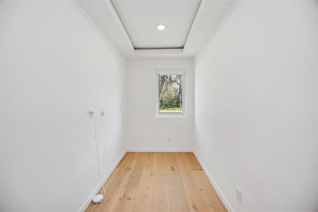 spare room featuring light hardwood / wood-style floors and a tray ceiling