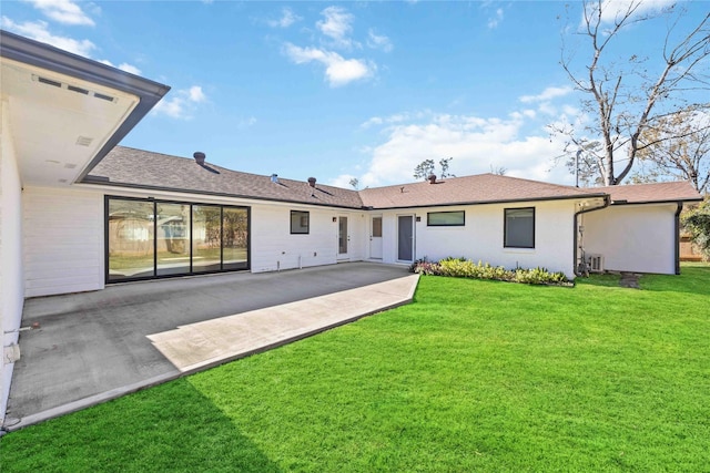 rear view of property with a yard and a patio