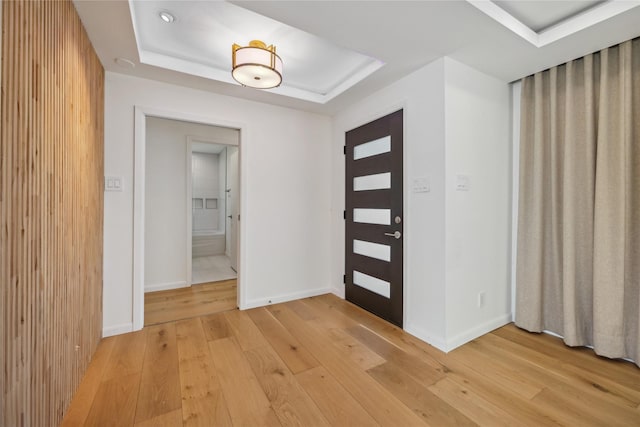 foyer featuring a raised ceiling and hardwood / wood-style flooring