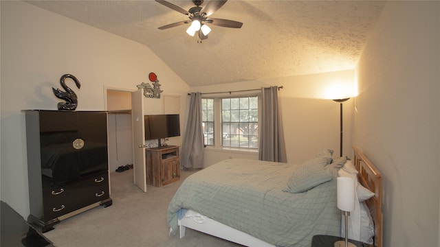 bedroom with vaulted ceiling, light carpet, ceiling fan, and a textured ceiling