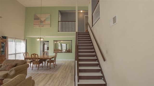 staircase featuring a high ceiling and hardwood / wood-style floors