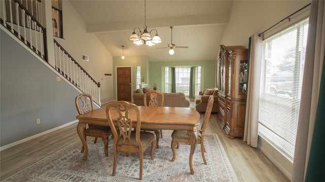 dining room with high vaulted ceiling, ceiling fan with notable chandelier, beam ceiling, and light hardwood / wood-style flooring