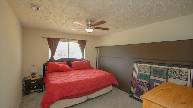 carpeted bedroom featuring a textured ceiling and ceiling fan