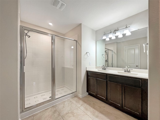 bathroom featuring tile patterned flooring, vanity, and a shower with shower door