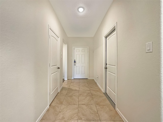 hall with light tile patterned floors