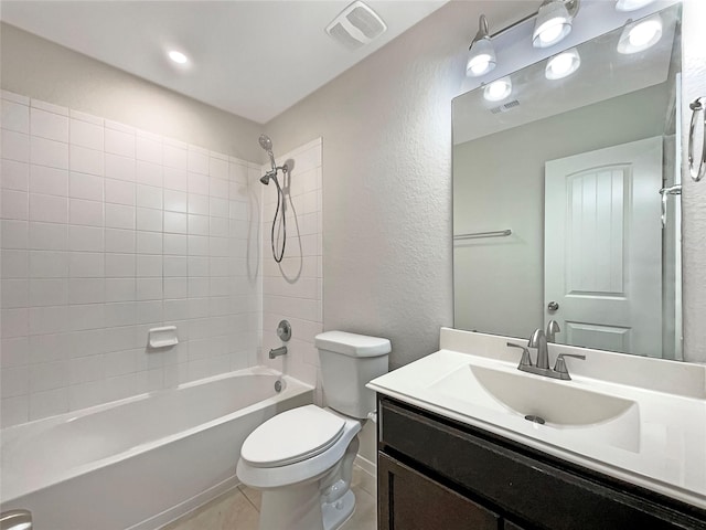 full bathroom with vanity, tiled shower / bath combo, tile patterned floors, and toilet