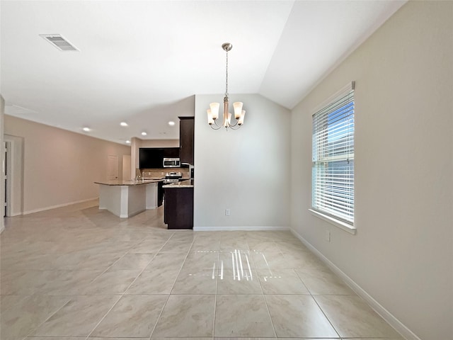 spare room with lofted ceiling, light tile patterned floors, and a notable chandelier