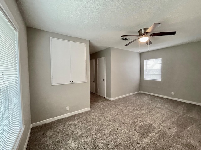 carpeted spare room with ceiling fan and a textured ceiling