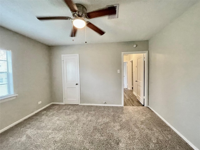 unfurnished bedroom featuring dark colored carpet and ceiling fan