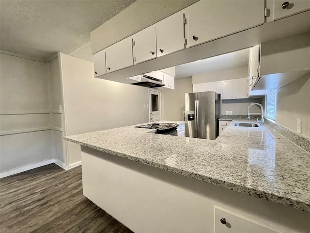 kitchen featuring sink, white cabinets, stainless steel fridge, range, and kitchen peninsula