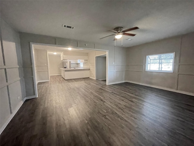 unfurnished living room featuring dark hardwood / wood-style flooring and ceiling fan