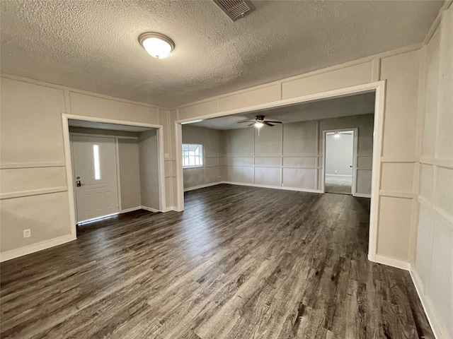 interior space featuring ceiling fan, a textured ceiling, and dark hardwood / wood-style flooring