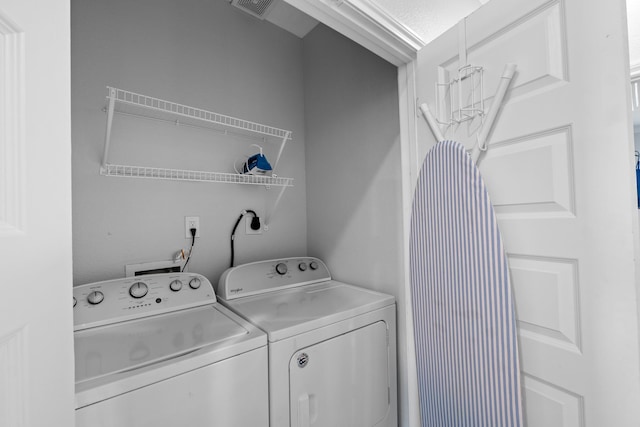 clothes washing area featuring separate washer and dryer