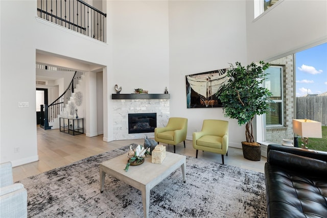 living room with a towering ceiling and light wood-type flooring