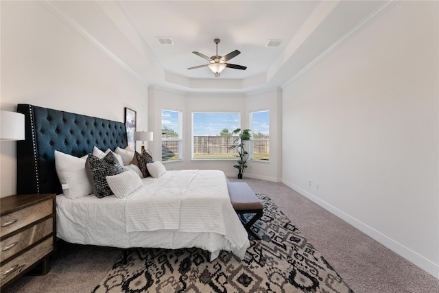 carpeted bedroom with a raised ceiling and ceiling fan