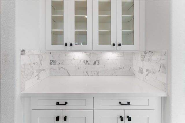 bar with tasteful backsplash and white cabinets