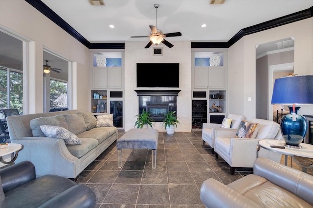 living room with crown molding, a large fireplace, and ceiling fan