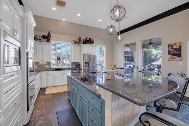 kitchen featuring a spacious island, appliances with stainless steel finishes, white cabinets, and blue cabinets