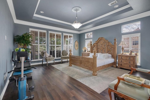 bedroom with crown molding, dark hardwood / wood-style floors, and a tray ceiling