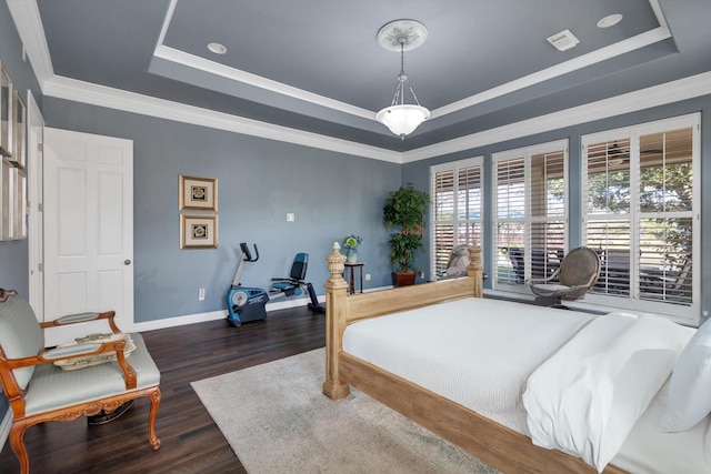 bedroom featuring dark wood-type flooring, ornamental molding, and a raised ceiling