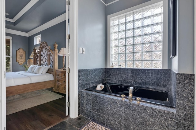 bathroom with tiled tub, hardwood / wood-style flooring, a wealth of natural light, and ornamental molding