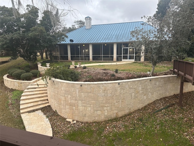 rear view of property featuring a sunroom