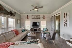 living room with crown molding, a healthy amount of sunlight, and a barn door