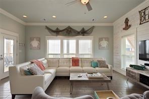 living room with ornamental molding, dark hardwood / wood-style floors, and ceiling fan