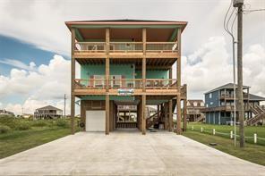 1129 Blue Water Dr, Crystal Beach, TX 77650 - view of front facade with a garage, a carport, and a balcony