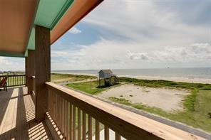 balcony featuring a water view and a beach view