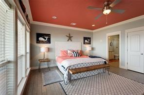 bedroom featuring connected bathroom, hardwood / wood-style floors, and crown molding