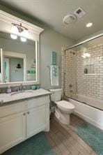 full bathroom with vanity, hardwood / wood-style floors, combined bath / shower with glass door, and toilet