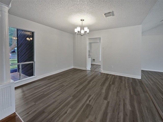 unfurnished room with dark hardwood / wood-style flooring, a notable chandelier, a textured ceiling, and ornate columns